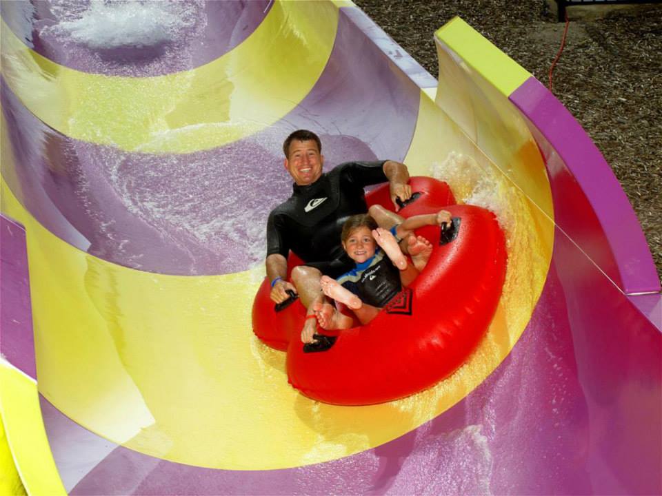man and child going down water slide